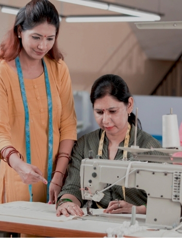 female guiding male textile worker marking on garment